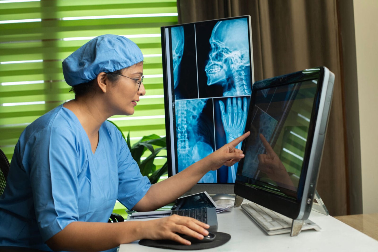 Doctor analyzing X-ray on computer screen.