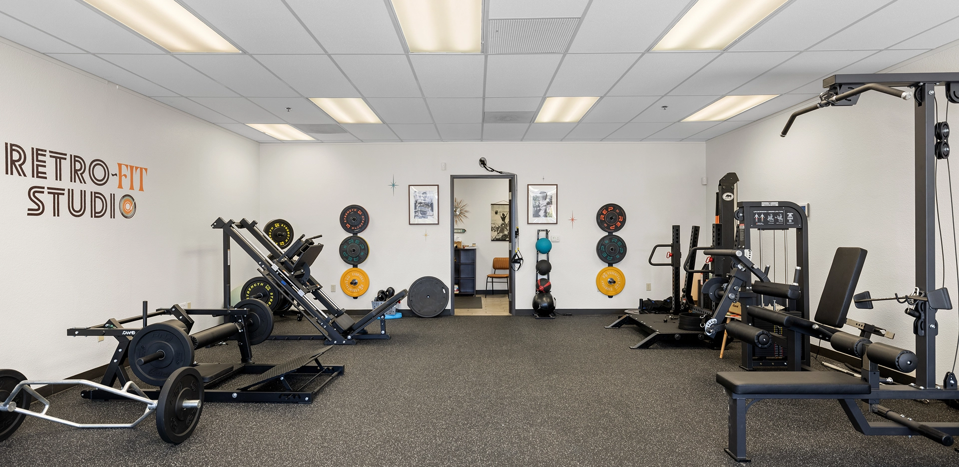Gym with various exercise equipment and weights.